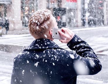 Mann am Handy im Winter