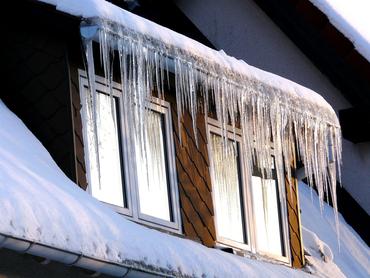 schneebedecktes Dach mit Eiszapfen