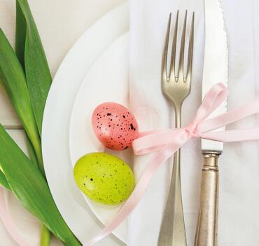 Easter table setting with pink tulips on white wooden background. Top view
