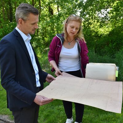 Simone Siermann und Benjamin Kanngießer schauen sich in der alten Bauakte die Maße und weitere Planungsdetails des Denkmals an.